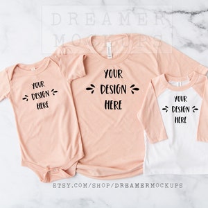 May include: A set of three peach-colored shirts with the text "Your Design Here" on each. The shirts are a baby onesie, a t-shirt, and a long-sleeved baseball tee.