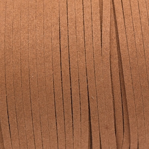 Op de afbeelding: Een spoel met bruin suède koord, perfect voor knutselprojecten.