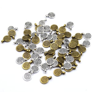 May include: A collection of spiral-shaped metal charms in antique gold and silver tones. Each charm features a spiral design and a small loop for attaching to jewelry or other crafts. The charms are scattered on a white surface.
