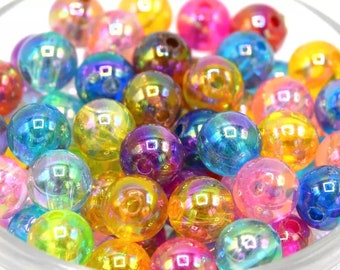 May include: A bowl filled with iridescent rainbow colored round beads. The beads are made of glass and have a shiny finish.