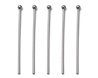 Puede incluir: Cinco alfileres de metal plateado con cabezas redondeadas. Los alfileres miden aproximadamente 5 cm de largo.