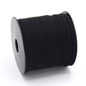 Op de afbeelding: Een spoel met zwart suède koord, gewikkeld om een zwarte plastic spoel.