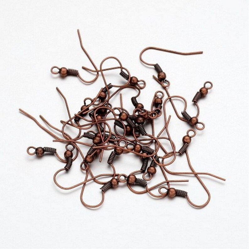 May include: A pile of copper-colored earring hooks with a small ball at the top of each hook.