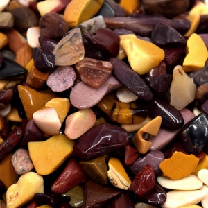 Peut inclure: Gros plan d'un bol rempli de petites pierres polies de différentes couleurs, notamment jaune, marron, rouge et violet.