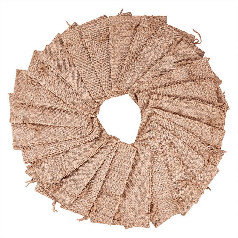 May include: A set of 30 small, brown burlap drawstring bags arranged in a circle. The bags are made of natural burlap fabric and have a rustic, earthy look.