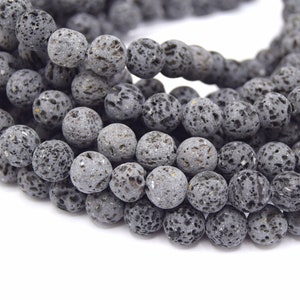 Peut inclure: Un brin de perles de roche volcanique gris foncé. Les perles sont rondes et ont une surface rugueuse et texturée.