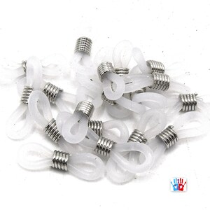 May include: A pile of white plastic and silver eyeglass cord end tips. The tips are designed to attach to eyeglass cords or chains.