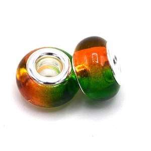 May include: Two glass beads with a silver core. The beads are orange, yellow, and green.