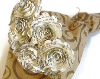以下が含まれることがあります： 本のページから作られた紙の花のブーケ。渦巻き模様の茶色の紙で包まれています。