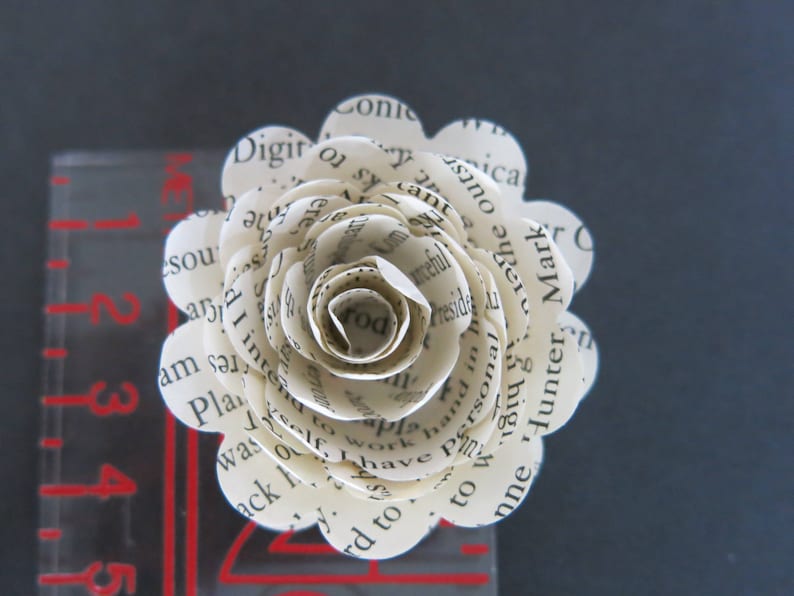 Peut inclure: Une fleur en papier blanche faite de pages de livre, avec du texte comprenant "Personal", "Hunter", "Mark", "Conic", "Digito", "America", "Plan", "was", "to", "work", "self", "have", "and", "in", "the", "outst", "am", "s", "rd", "I", "inte", "nosa", "fome", "cant", "arceful", "to", "w8142", "ks", "to", "ica", "a", "the", "nne",  "hand", "of", "the", "most", "important", "things", "in", "life", "are", "the", "people", "you", "love", "and", "the", "memories", "you", "make", "together".