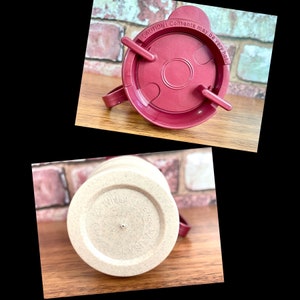 May include: A close-up of a beige travel mug with a brown lid. The lid has a warning label that reads "CAUTION! Contents may be very hot".