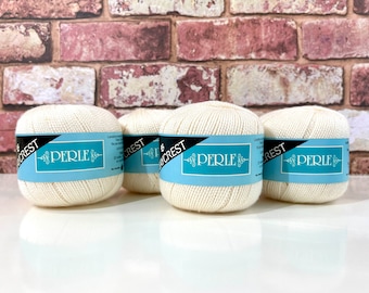 May include: Four balls of white yarn with blue and black labels that read "Perle" and "Crest".