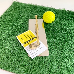 May include: A gold-coloured golf club keychain on a silver background with a golf ball and a business card that reads "vinlaqedoohickeys" with the text "Vintage" and "Lisa U" on the card.  Thank you for your small business. I really do appreciate it and hope to see you again.