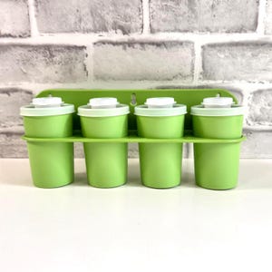 Peut inclure: Un support mural vert citron pour épices comprenant quatre récipients assortis de couleur vert citron avec des couvercles blancs. Le support possède un panneau arrière rectangulaire avec deux trous de fixation et une étagère horizontale.