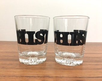 May include: Two clear glass tumblers with black lettering that reads "WHISKEY" on each glass.