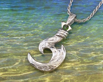 May include: A silver Hawaiian hook necklace pendant with intricate floral designs. The pendant is on a silver rope chain.