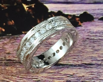 Puede incluir: Una banda de plata con un diseño decorativo y dos filas de piedras transparentes.