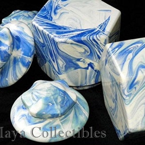 May include: Set of four blue and white ceramic lidded jars with a marbled design. The jars are in various shapes and sizes.