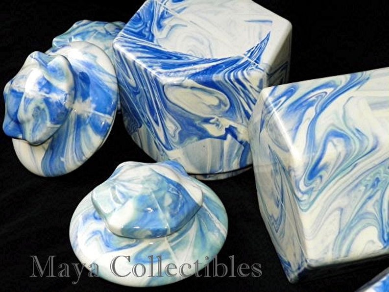 May include: Set of four blue and white ceramic lidded jars with a marbled design. The jars are in various shapes and sizes.