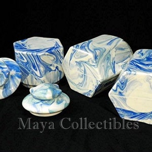 May include: Set of four blue and white ceramic hexagonal boxes with lids. The boxes have a marbled design and are perfect for storing small items.