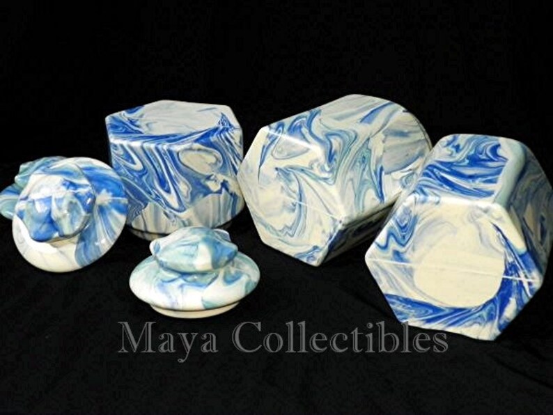 May include: Set of four blue and white ceramic hexagonal boxes with lids. The boxes have a marbled design and are perfect for storing small items.
