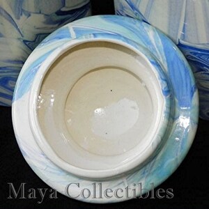 May include: A white ceramic lid with a blue and white marbled design. The lid is for a canister or jar.