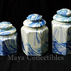 May include: Three octagonal ceramic canisters with blue and white marbled designs. The canisters have lids and are of varying sizes.