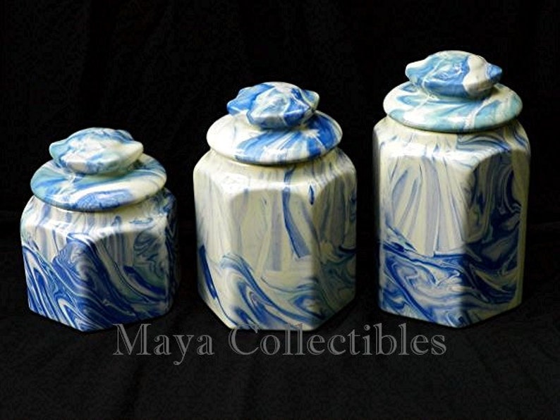 May include: Three octagonal ceramic canisters with blue and white marbled designs. The canisters have lids and are of varying sizes.