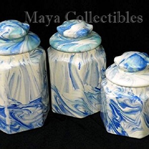 May include: Set of three blue and white ceramic canisters with octagonal shapes and lids. The canisters have a marbled design.