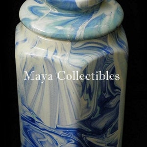 May include: A blue and white ceramic jar with a lid. The jar has a marbled design and a hexagonal shape. The lid is also marbled and has a rounded top.