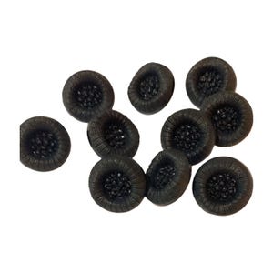 Pode incluir: Uma coleção de dez pequenos botões pretos em forma de pneu. Cada botão tem um padrão de banda de rodagem detalhado e um perfil ligeiramente arredondado. Os botões estão sobre um fundo branco.
