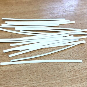 Peut inclure: Un tas de fils de nez en plastique blanc pour masques faciaux.