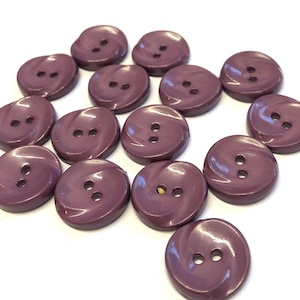 May include: A collection of 15 purple swirl buttons, each with two holes. The buttons are made from a shiny plastic material.