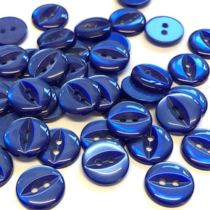 May include: A collection of blue plastic buttons with two holes each. The buttons have a shiny, iridescent finish.
