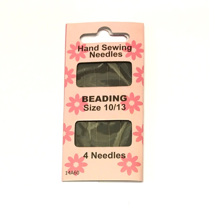 May include: A pink and white package of 4 beading needles, size 10/13. The package has a floral design and says "Hand Sewing Needles" and "Beading Size 10/13".