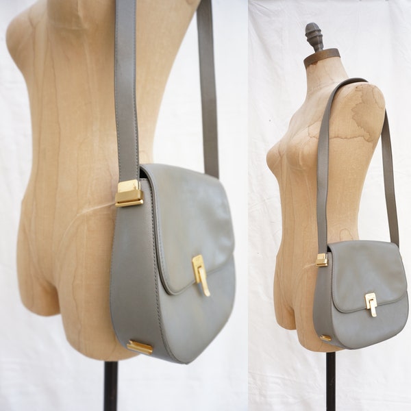 90's Pied-a-Terre grey leather shoulder saddle bag with gold toned hardware and unique adjustable strap