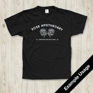 May include: Black t-shirt with white text that reads "ROSE APOTHECARY" and a graphic of two roses. The text below the roses reads "HANDCRAFTED WITH CARE".