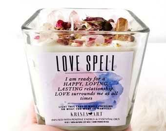 May include: A square glass candle jar with a white candle and crystals. The label reads "LOVE SPELL" and includes the text "I am ready for a HAPPY, LOVING, LASTING relationship. LOVE surrounds me at all times."  The label also includes the text "LIGHT THIS CANDLE WHILE FOCUSING ON WHAT YOU WANT TO MANIFEST."  The label is decorated with a watercolor-style background. The candle is infused with positive energy and essential oils. The candle is 10 oz and is made with 100% natural soy wax. It is hand-poured in the USA.