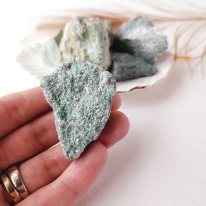 May include: A close-up of a green and red ruby in matrix crystal. The crystal is rough and has a natural, unpolished look.