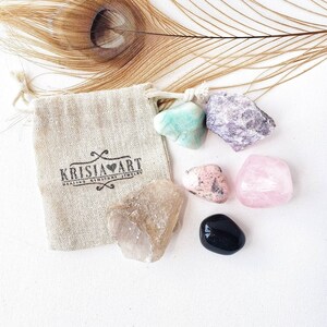 Puede incluir: Un conjunto de seis cristales pulidos en una peque&ntilde;a bolsa de tela beige con cord&oacute;n. Los cristales son: amatista, cuarzo rosa, cuarzo transparente, aventurina verde, rodonita rosa y obsidiana negra.