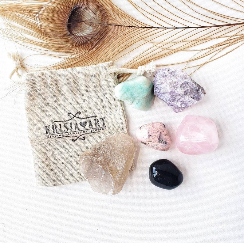Puede incluir: Un conjunto de seis cristales pulidos en una peque&ntilde;a bolsa de tela beige con cord&oacute;n. Los cristales son: amatista, cuarzo rosa, cuarzo transparente, aventurina verde, rodonita rosa y obsidiana negra.