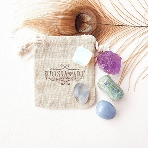 May include: A small pouch containing five tumbled stones: a clear white, a light blue, a dark blue, a green, and a purple.