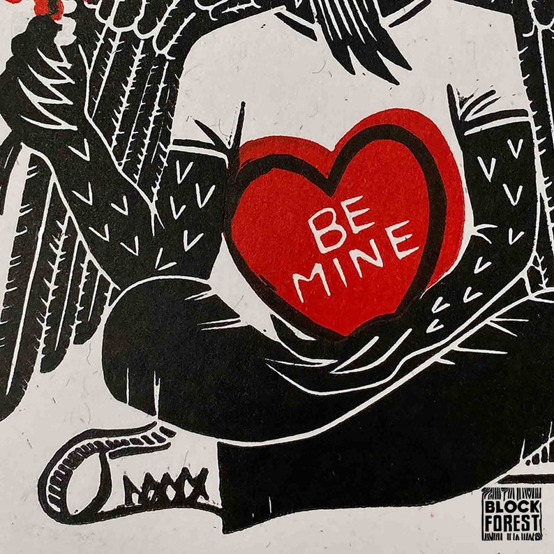May include: Black and white illustration of a winged figure holding a red heart-shaped candy with the words "Be Mine" printed on it.