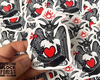 May include: A black and white sticker featuring a goat with wings and a heart in its hands. The goat is surrounded by flames and has a crown on its head. The sticker is on a white background and has the text "Block Forest" printed on it.