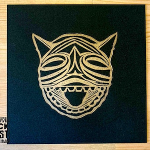 May include: A black square print with a gold, stylized animal face with a wide open mouth. The print has the text "BLOCK FOREST" in the bottom left corner.