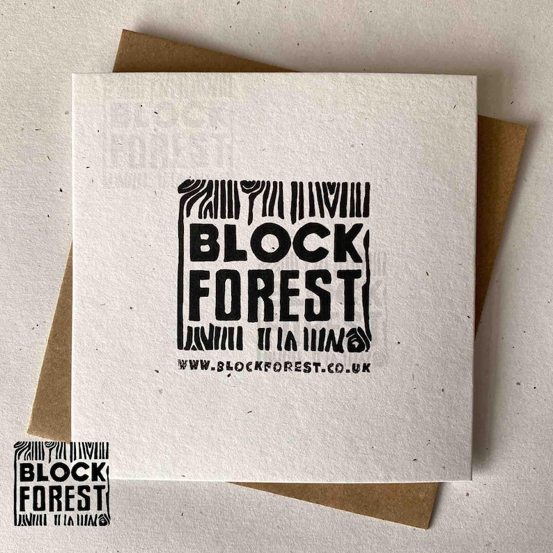 May include: Square white card with the words "BLOCK FOREST" in bold black letters. The card is on top of a brown envelope. The website address www.blockforest.co.uk is printed at the bottom of the card.