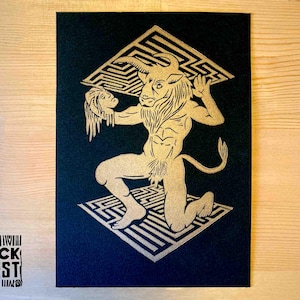 May include: A black and gold print of a Minotaur holding a human head, standing on a maze pattern. The print is titled "Block Forest".