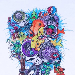May include: A white t-shirt with a colorful psychedelic design featuring a skull, an octopus, a fish, and a bear. The design is reminiscent of the Grateful Dead band.