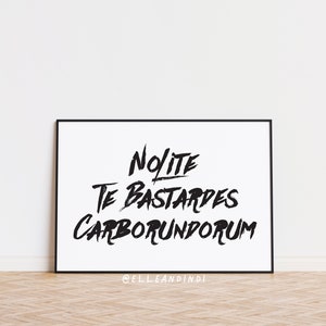 May include: Black and white framed print with the text "Nolite Te Bastardes Carborundum" and the social media handle "@elleandindi" at the bottom.