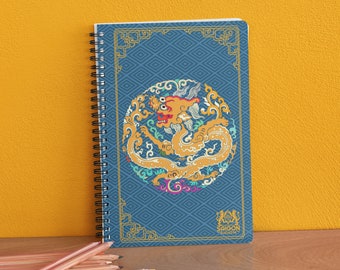May include: A blue spiral notebook with a gold dragon design and a blue and white geometric pattern. The notebook has the text "SAIGON  JOURNEY" on the bottom.